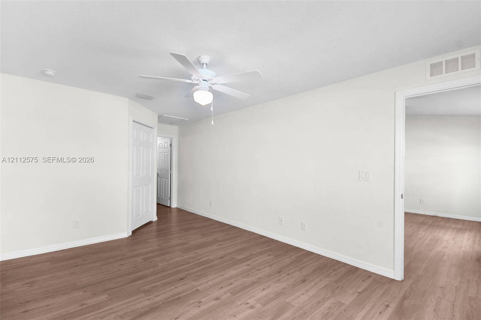 9041 E Broad, Labelle, FL 33935 Neutral-toned interior space featuring wood-finish flooring, a ceiling-mounted light fixture, and panel-style interior doors