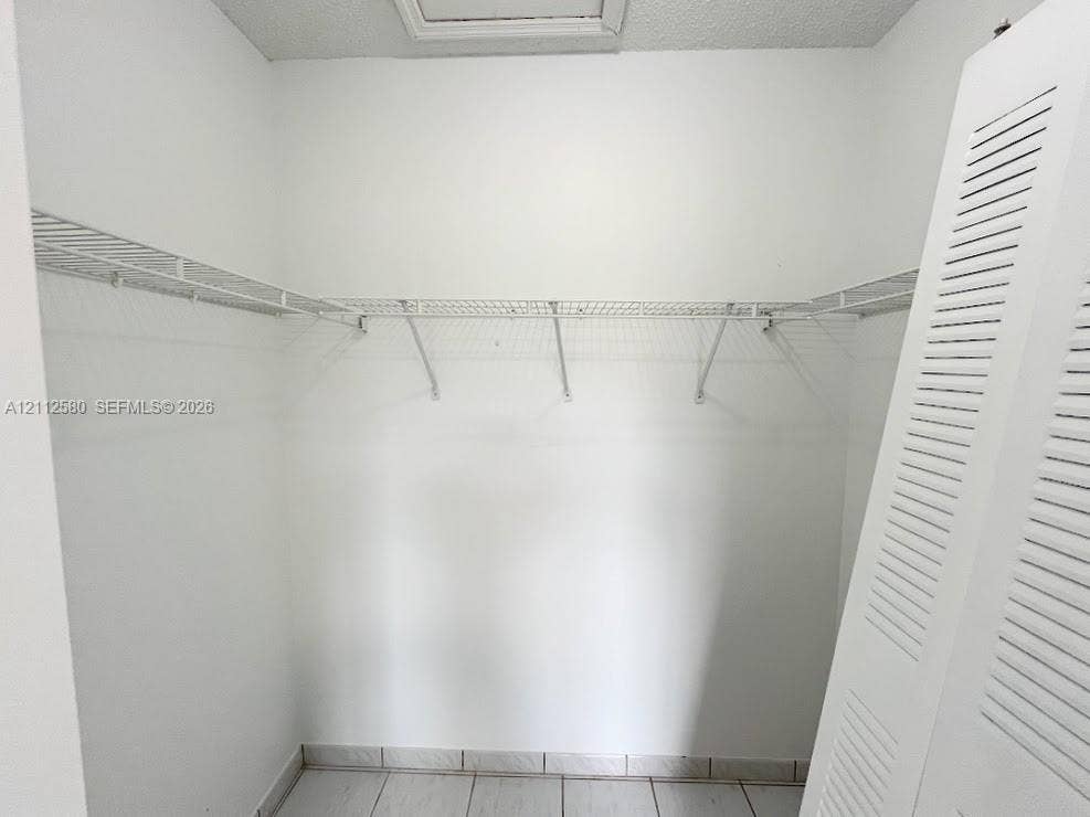 Storage area featuring wire shelving and white louvered doors