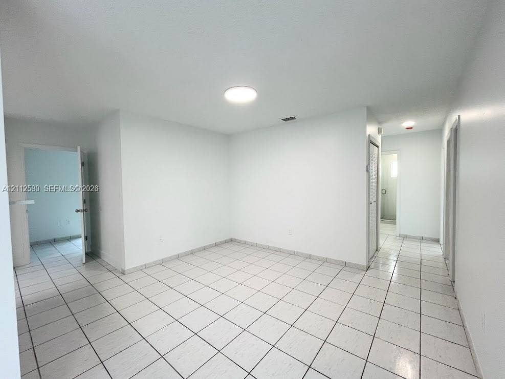 Interior space featuring white walls and white ceramic floor tiling