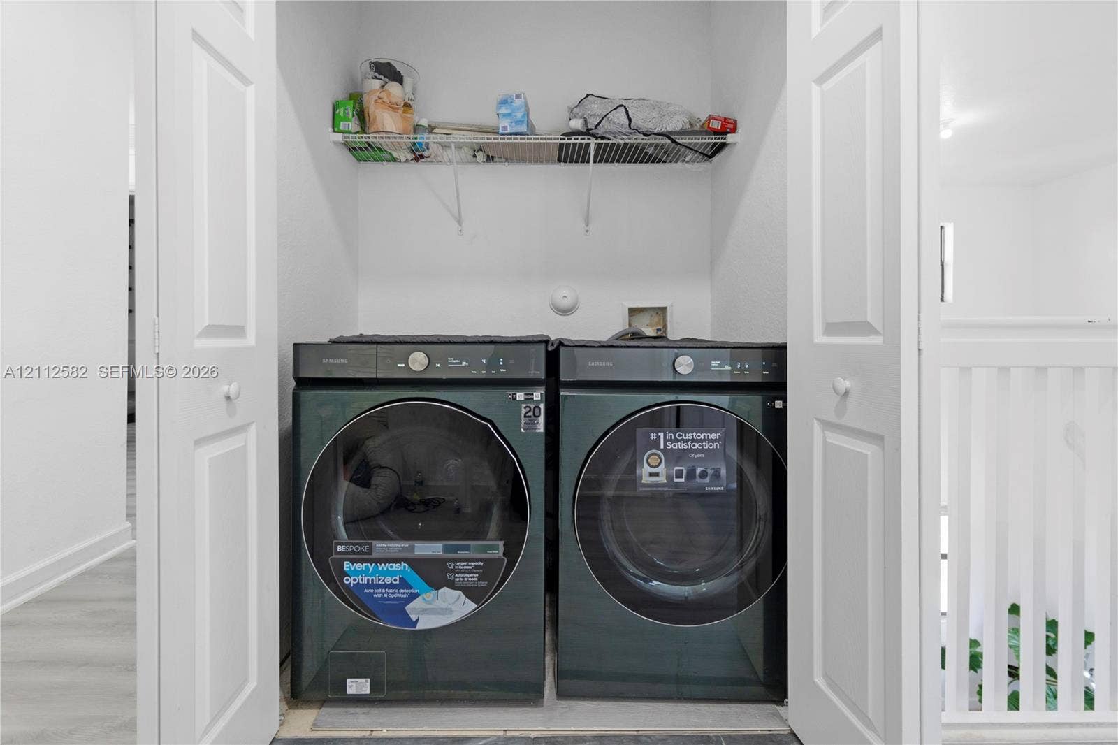 Laundry closet featuring double-panel doors, overhead wire shelving, and dedicated washer and dryer hookups