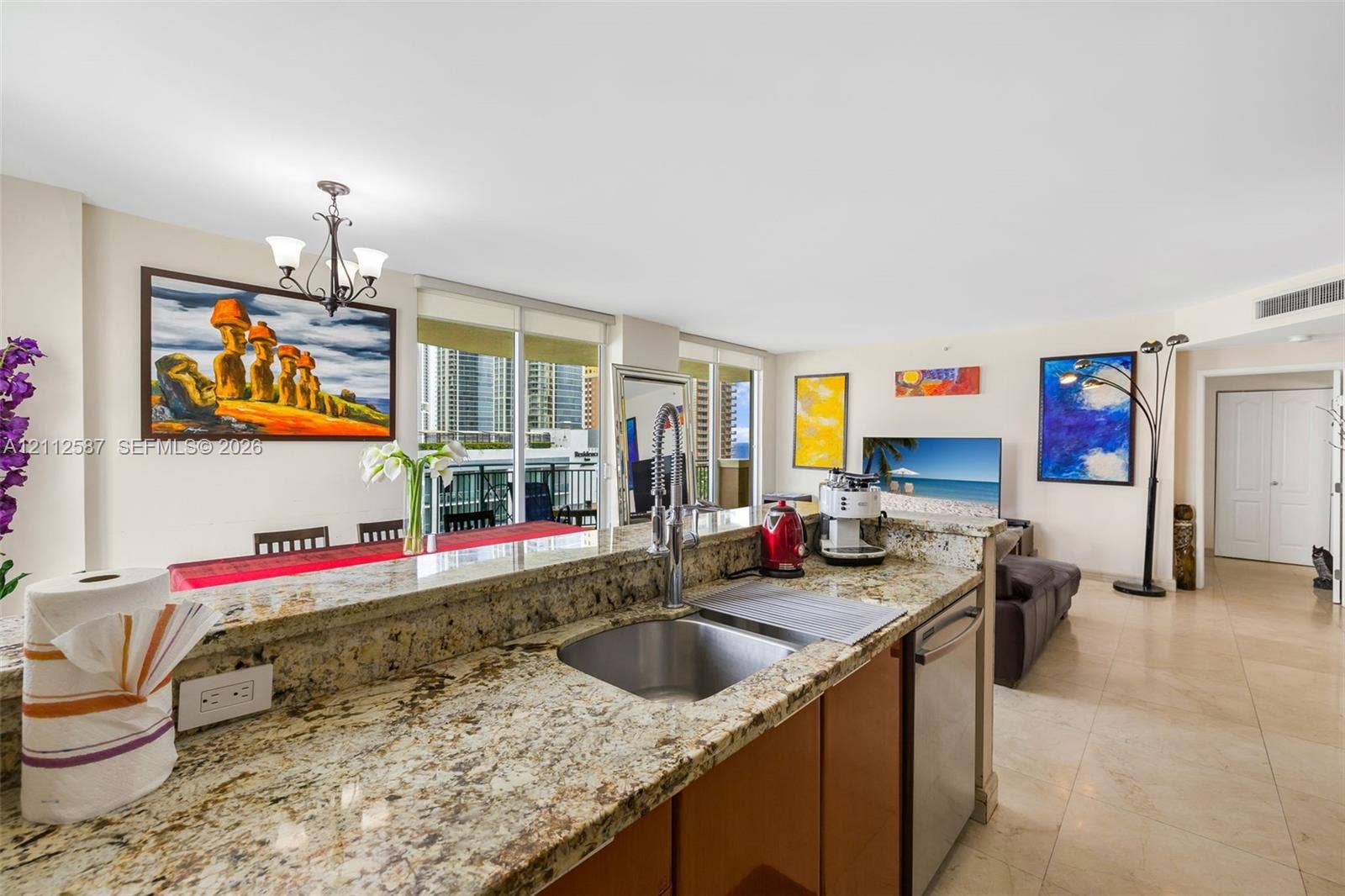 17555 NW Atlantic Boulevard, #1108, Sunny Isles Beach, FL 33160 Kitchen featuring natural stone countertops, stainless steel undermount sink with arched pull-down faucet, stainless steel dishwasher, and tile flooring