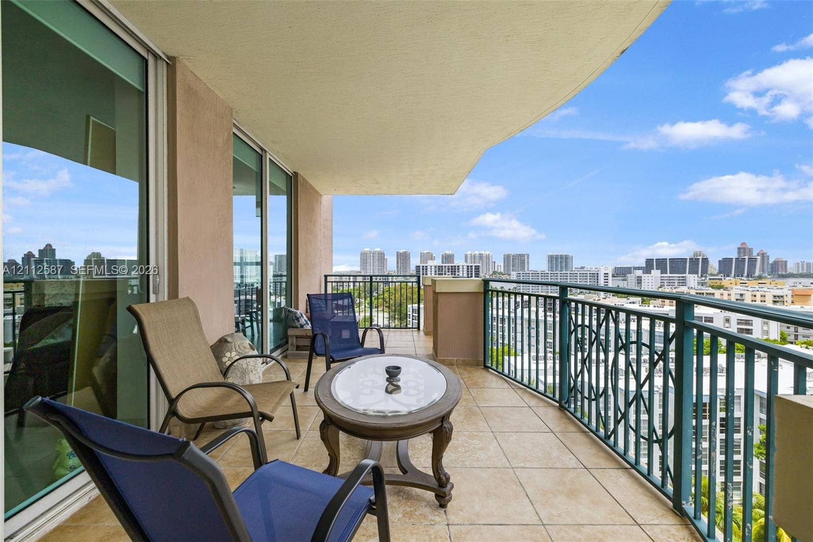 17555 NW Atlantic Boulevard, #1108, Sunny Isles Beach, FL 33160 Covered balcony featuring tile flooring, decorative metal railing, and floor-to-ceiling sliding glass doors