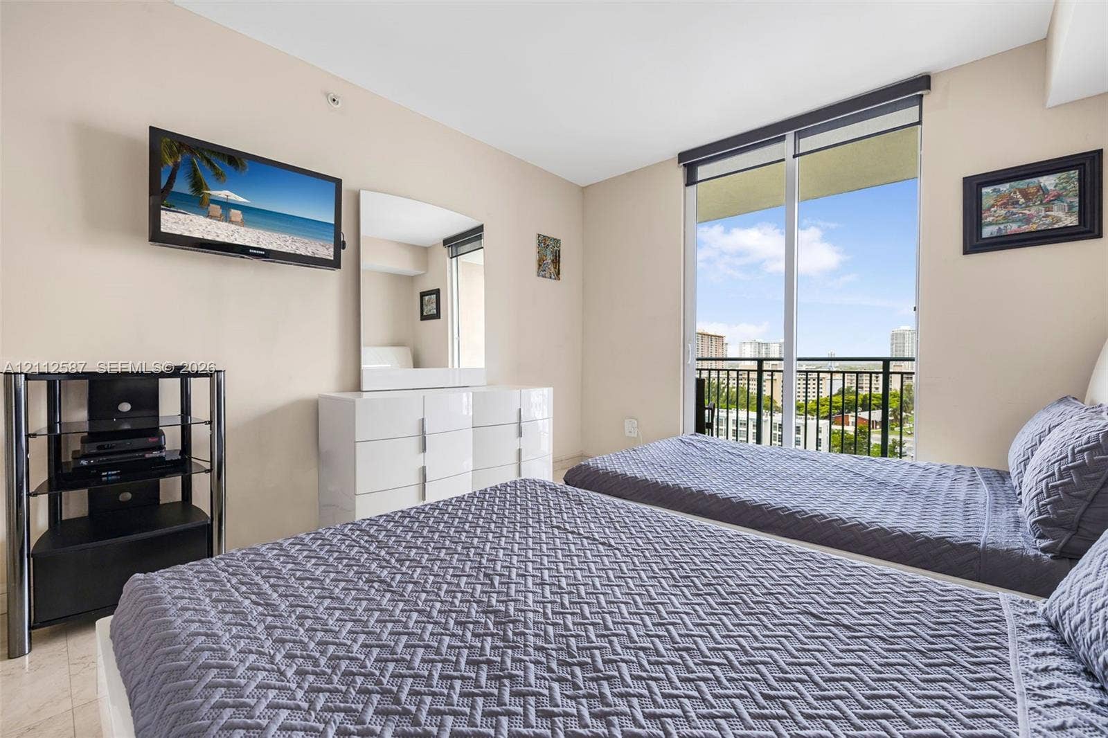 17555 NW Atlantic Boulevard, #1108, Sunny Isles Beach, FL 33160 Floor-to-ceiling sliding glass door, private exterior balcony with metal railing, and neutral stone-finish flooring
