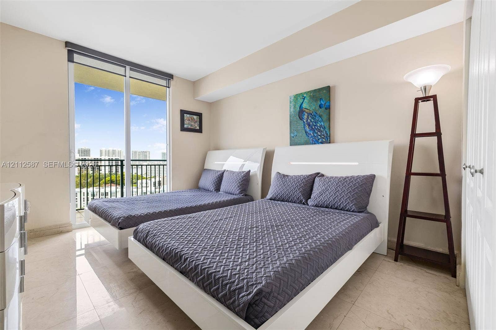 17555 NW Atlantic Boulevard, #1108, Sunny Isles Beach, FL 33160 Light-filled room featuring large-format stone tile flooring, floor-to-ceiling sliding glass doors, and a private balcony with metal railing