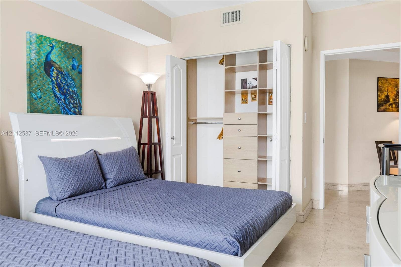 17555 NW Atlantic Boulevard, #1108, Sunny Isles Beach, FL 33160 Closet featuring built-in shelving and integrated drawer storage, neutral wall paint, and stone-finish flooring