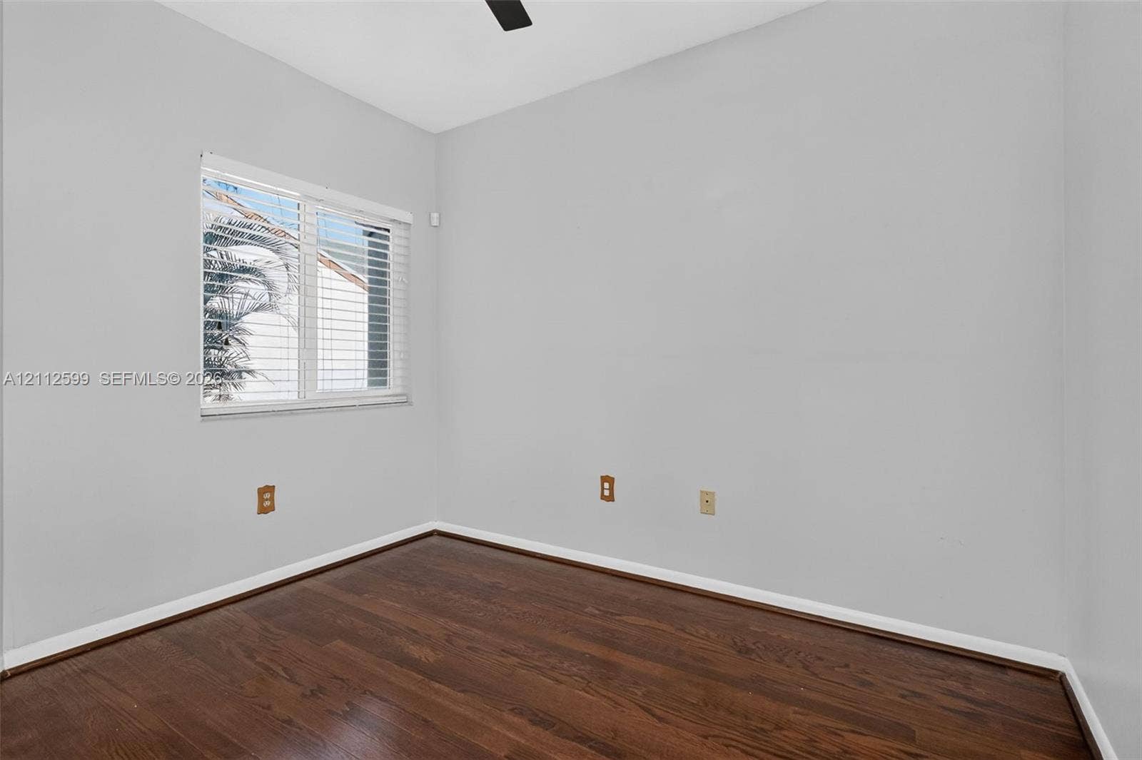7974 NW 190th Terrace, Hialeah, FL 33015 Room featuring wood-finish flooring, neutral wall paint, and a window with horizontal blinds