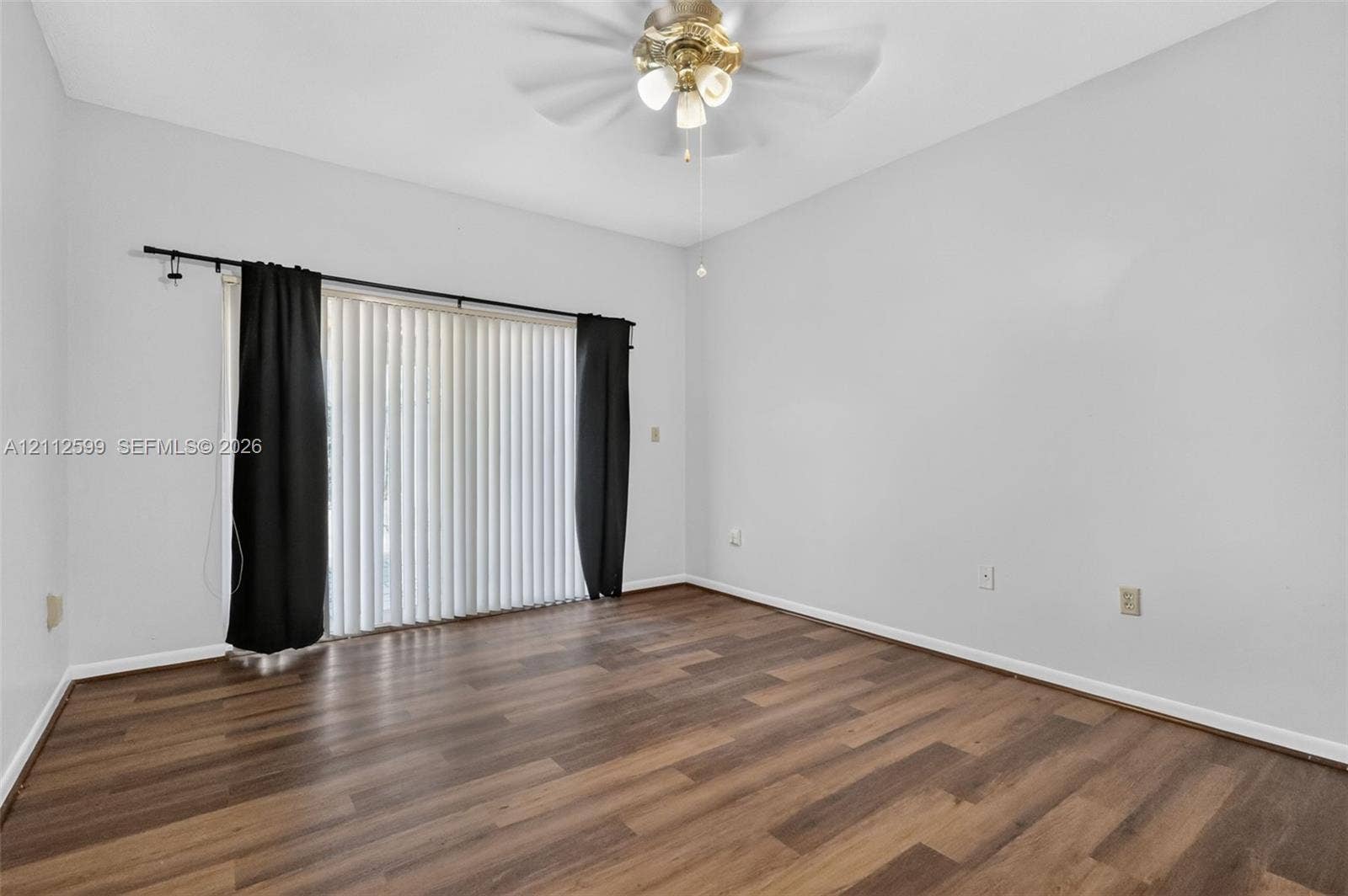 7974 NW 190th Terrace, Hialeah, FL 33015 Room featuring wood-finish flooring, sliding glass doors, and a ceiling fan with integrated lighting