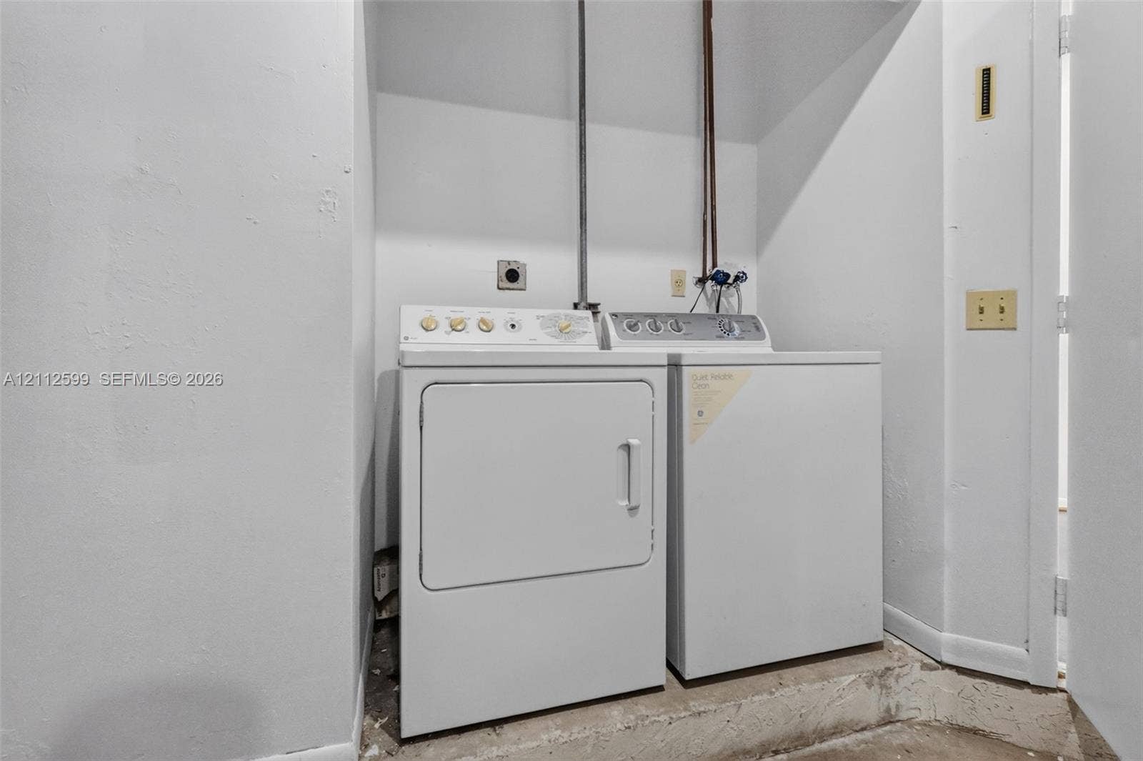 7974 NW 190th Terrace, Hialeah, FL 33015 Laundry alcove featuring side-by-side white washer and dryer units with dedicated utility hookups