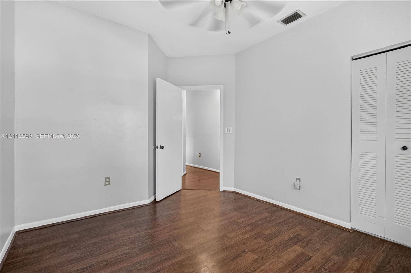 7974 NW 190th Terrace, Hialeah, FL 33015 Interior room featuring wood-finish flooring, a ceiling fan with integrated lighting, and a bi-fold louvered closet door