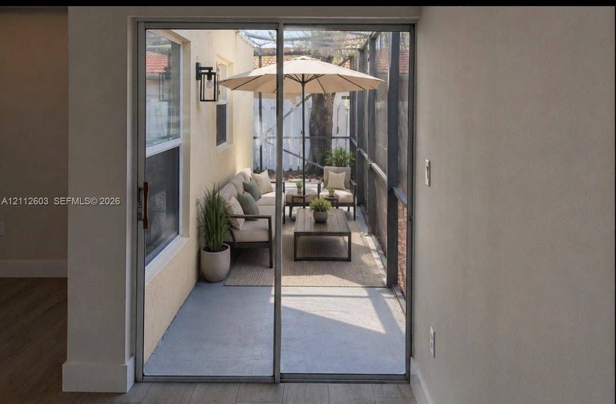 Screened-in patio featuring concrete flooring, a metal frame, exterior wall-mounted lighting, wrap around screened porch.
