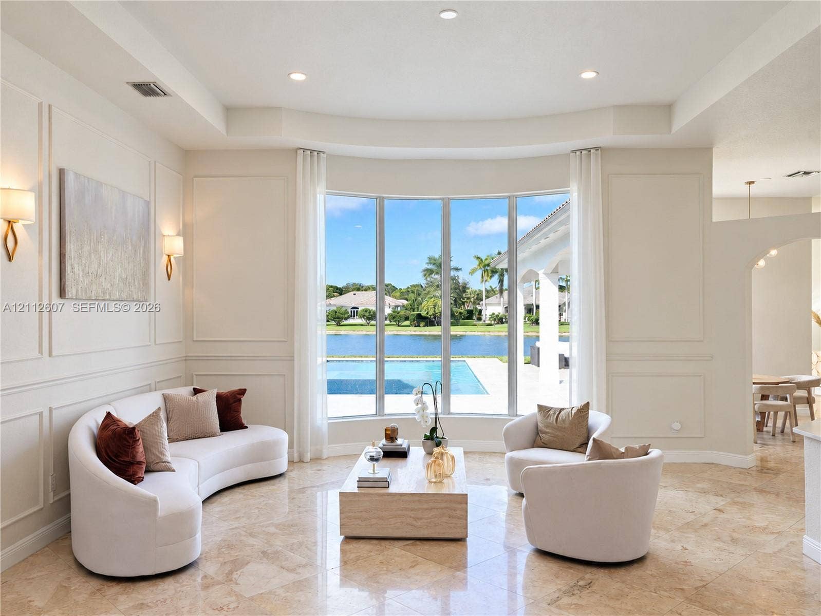 14443 S Jockey Circle S, Davie, FL 33330 Formal living space featuring a bay window, wall molding, recessed ceiling lighting, wall-mounted light fixtures, and stone flooring