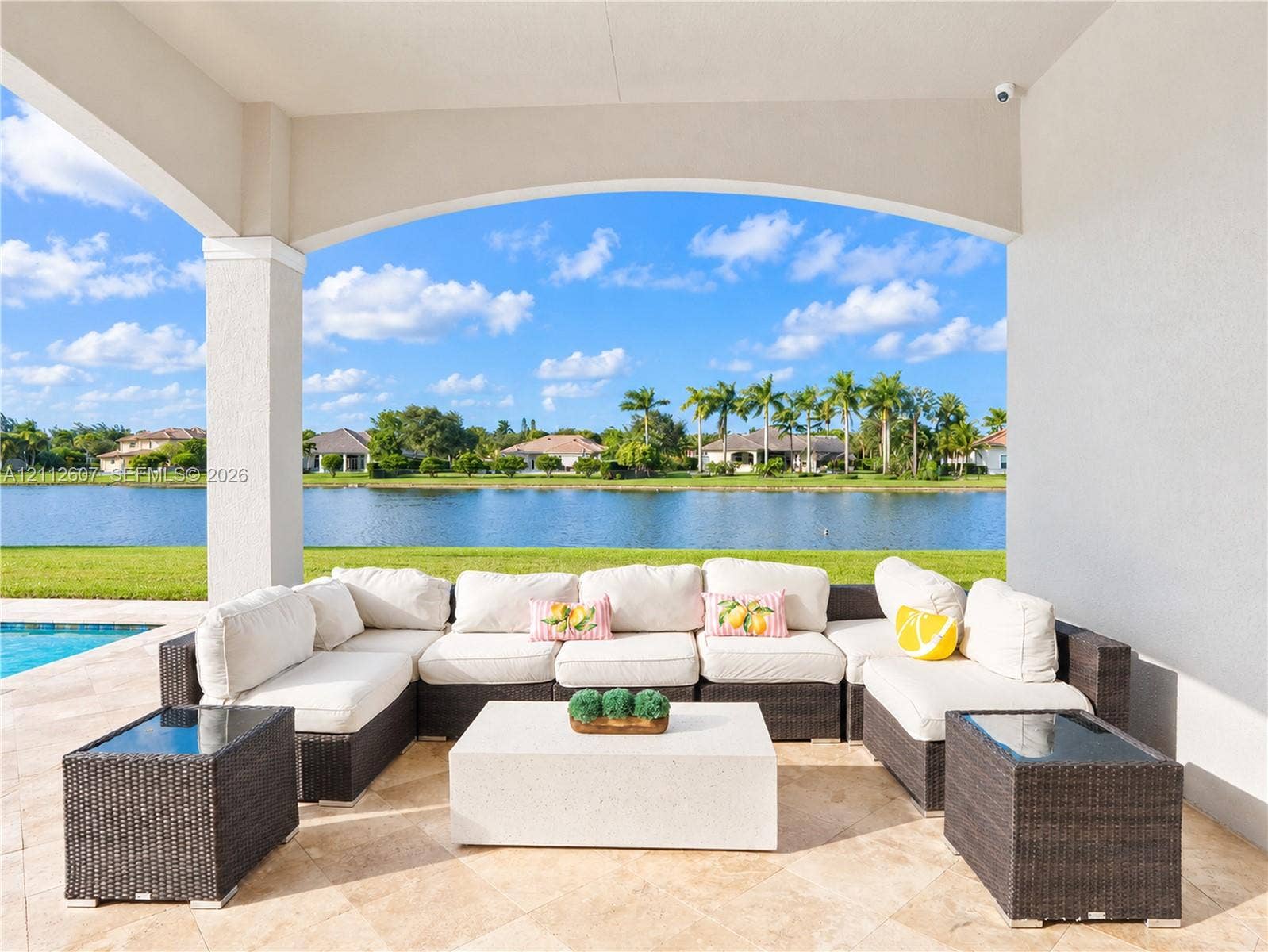 14443 S Jockey Circle S, Davie, FL 33330 Covered lanai featuring natural stone flooring, arched structural detailing, and water frontage