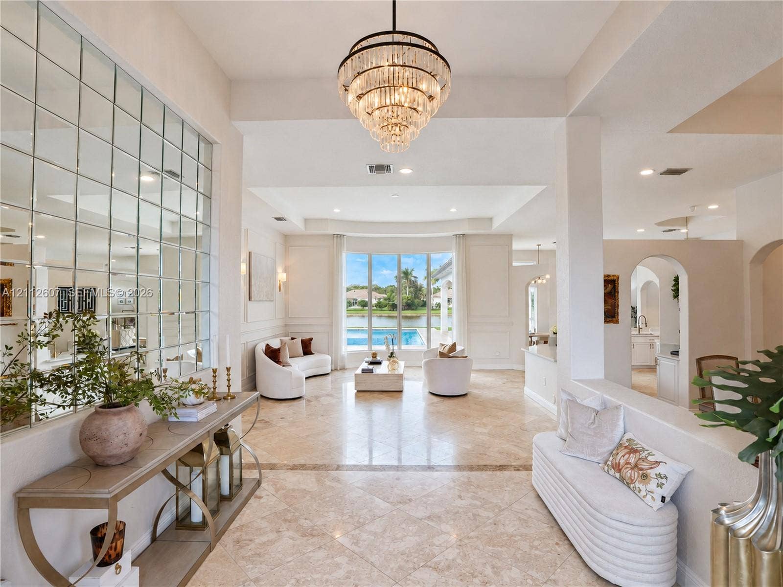 14443 S Jockey Circle S, Davie, FL 33330 Foyer featuring large-scale polished stone flooring, a multi-tiered crystal chandelier, and a floor-to-ceiling grid-patterned wall mirror