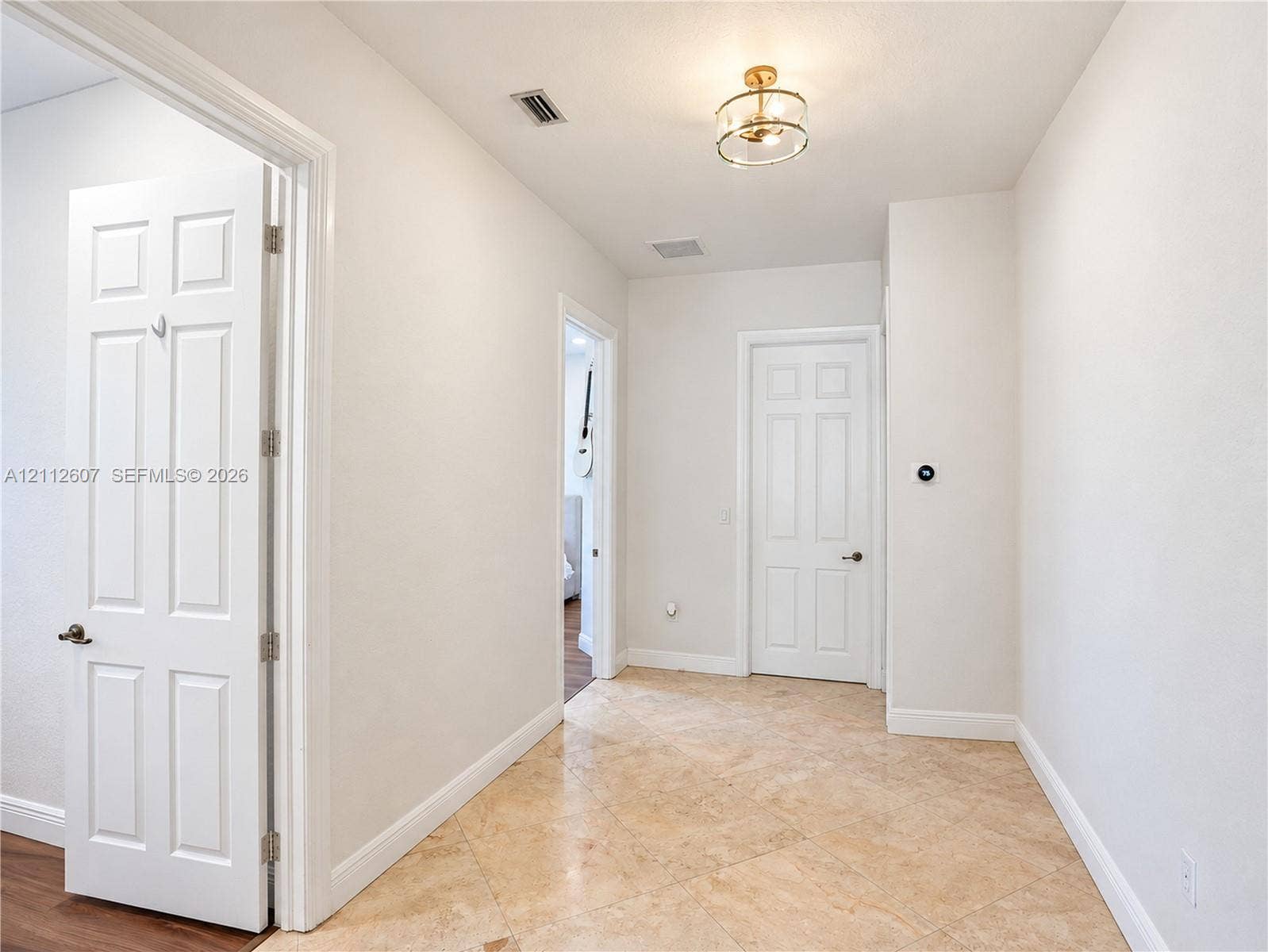14443 S Jockey Circle S, Davie, FL 33330 Hallway featuring diagonal-set tile flooring, multi-panel doors, and a decorative drum-style ceiling light fixture