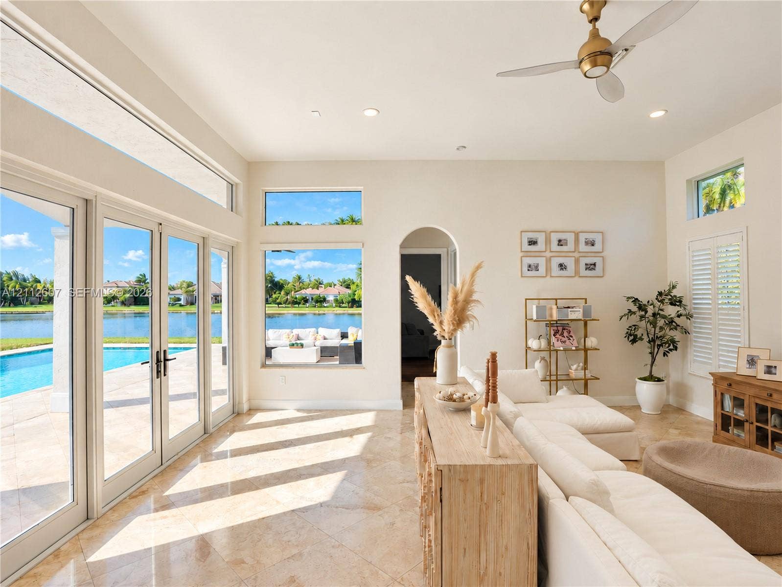 14443 S Jockey Circle S, Davie, FL 33330 Large-format windows, multi-panel glass patio doors, recessed lighting, arched entryway, and stone-finish flooring