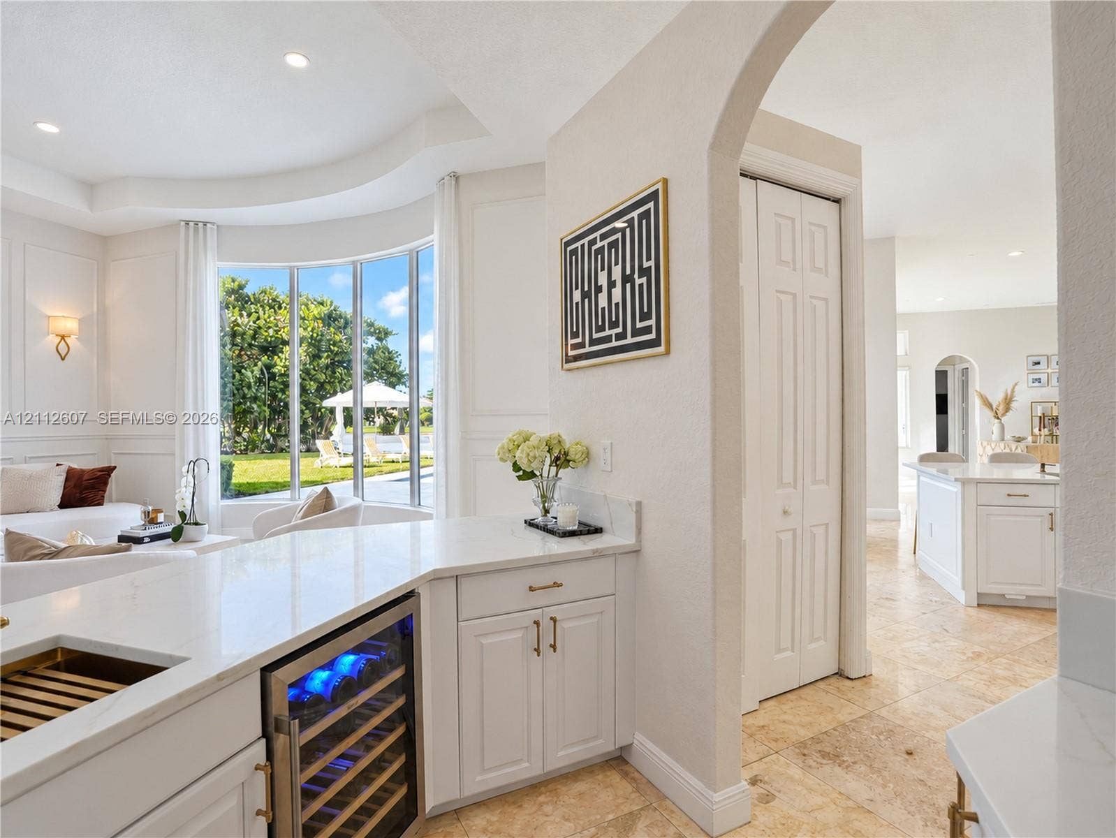 14443 S Jockey Circle S, Davie, FL 33330 Kitchen area featuring quartz countertops, a built-in wine refrigerator, paneled cabinetry, stone flooring, and an arched entryway