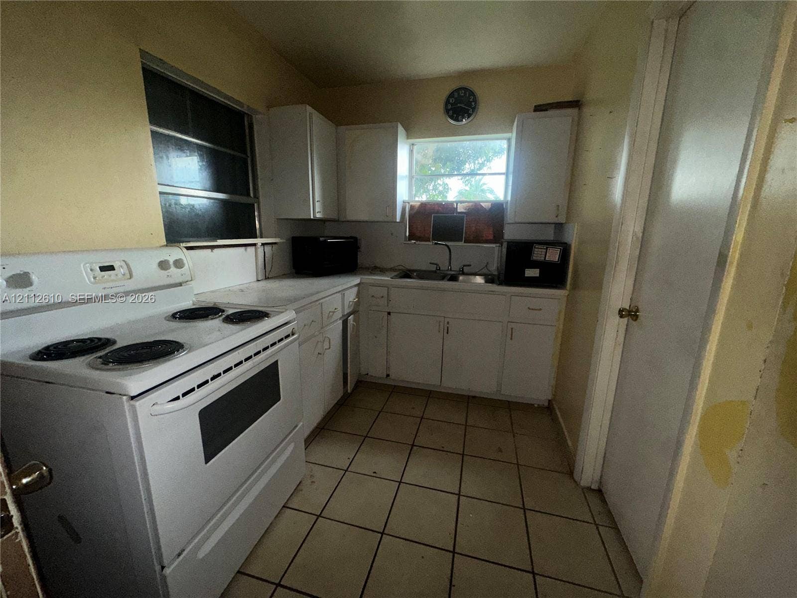 Hialeah, FL 33013 Kitchen featuring white cabinetry, a white electric range, a double-basin sink, and tile flooring