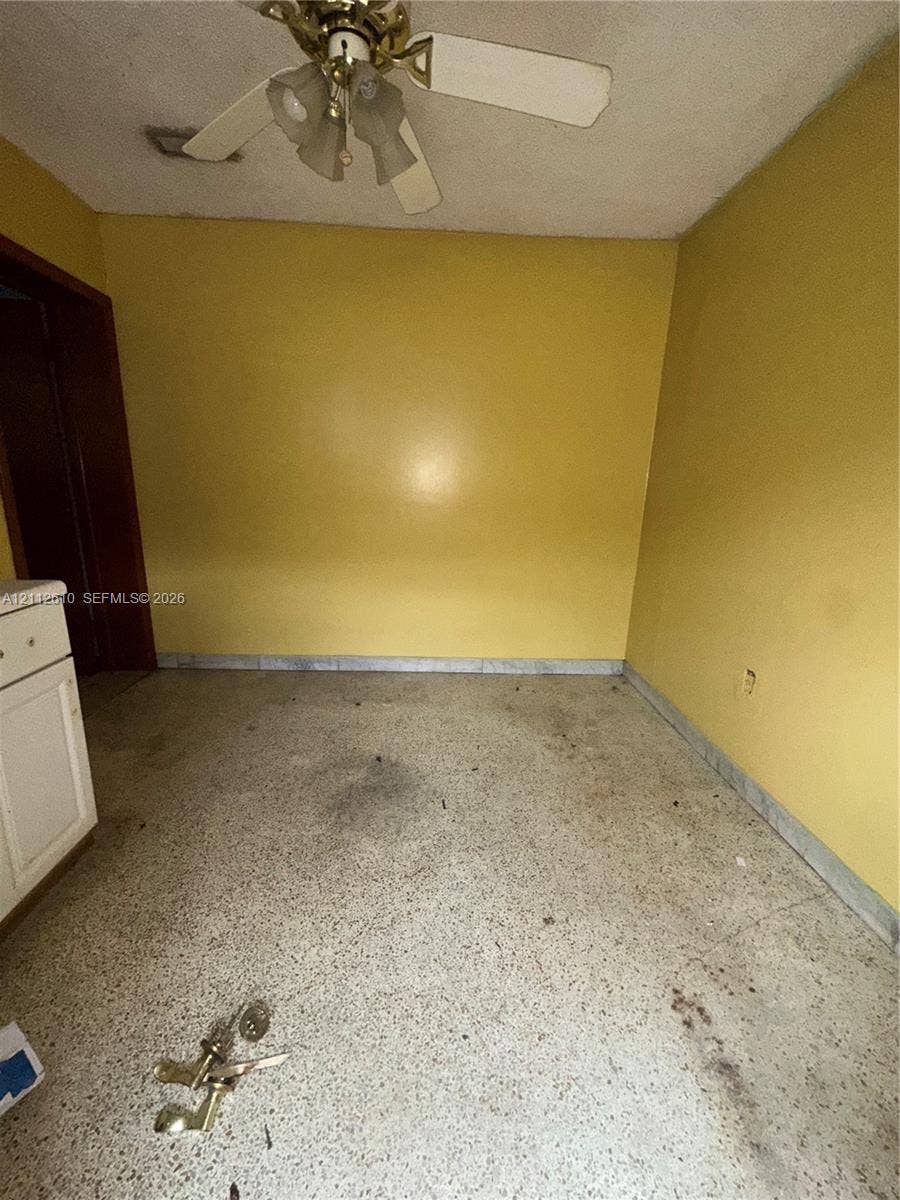 Hialeah, FL 33013 Interior space featuring terrazzo flooring, three-blade ceiling fan with integrated lighting, and white cabinet cabinetry