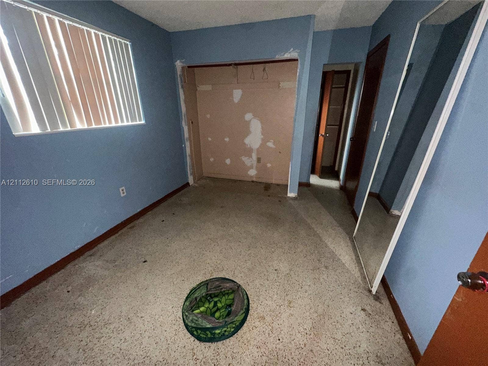 Hialeah, FL 33013 Interior room featuring a window with vertical blinds, closet space, and terrazzo flooring