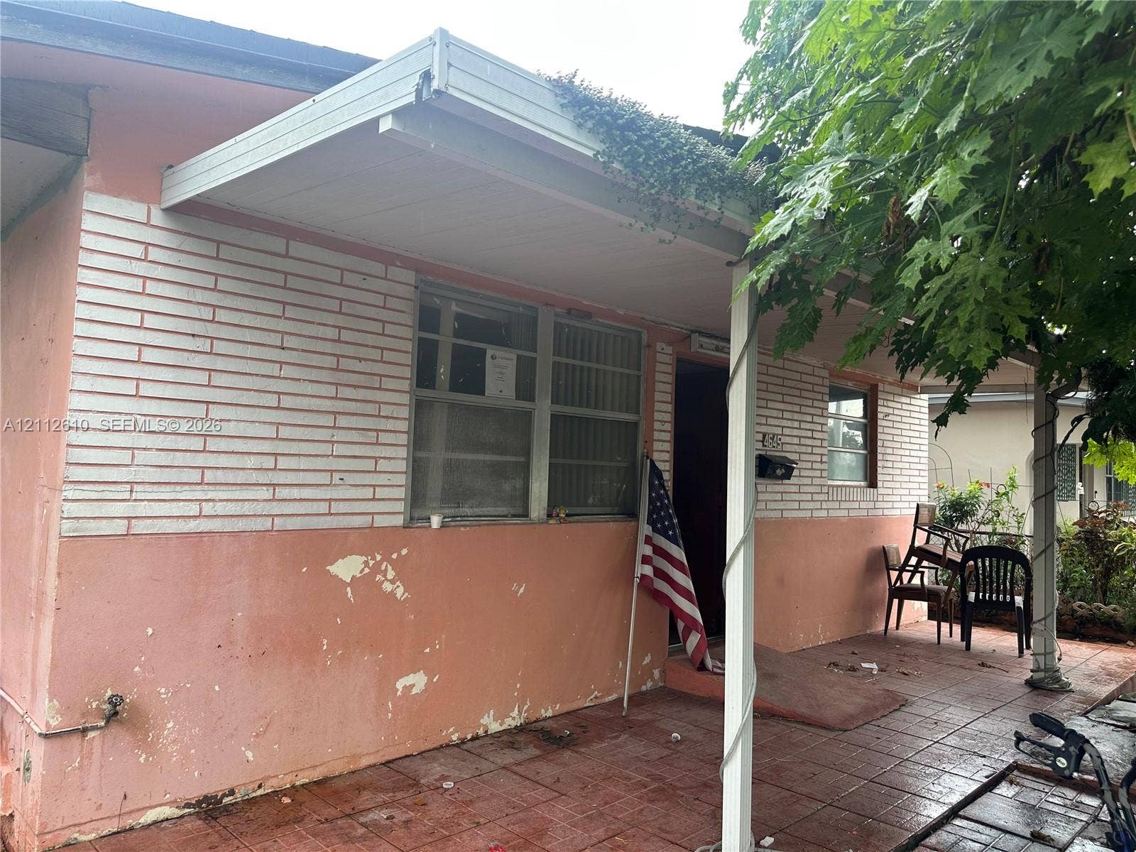 Hialeah, FL 33013 Exterior facade featuring painted brick masonry, a covered porch, and tile patio flooring