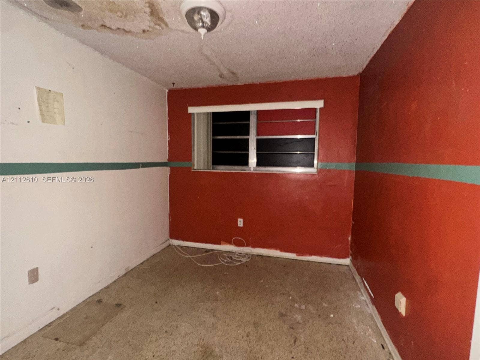 Hialeah, FL 33013 Room featuring painted walls, a horizontal sliding window, and a ceiling-mounted light fixture
