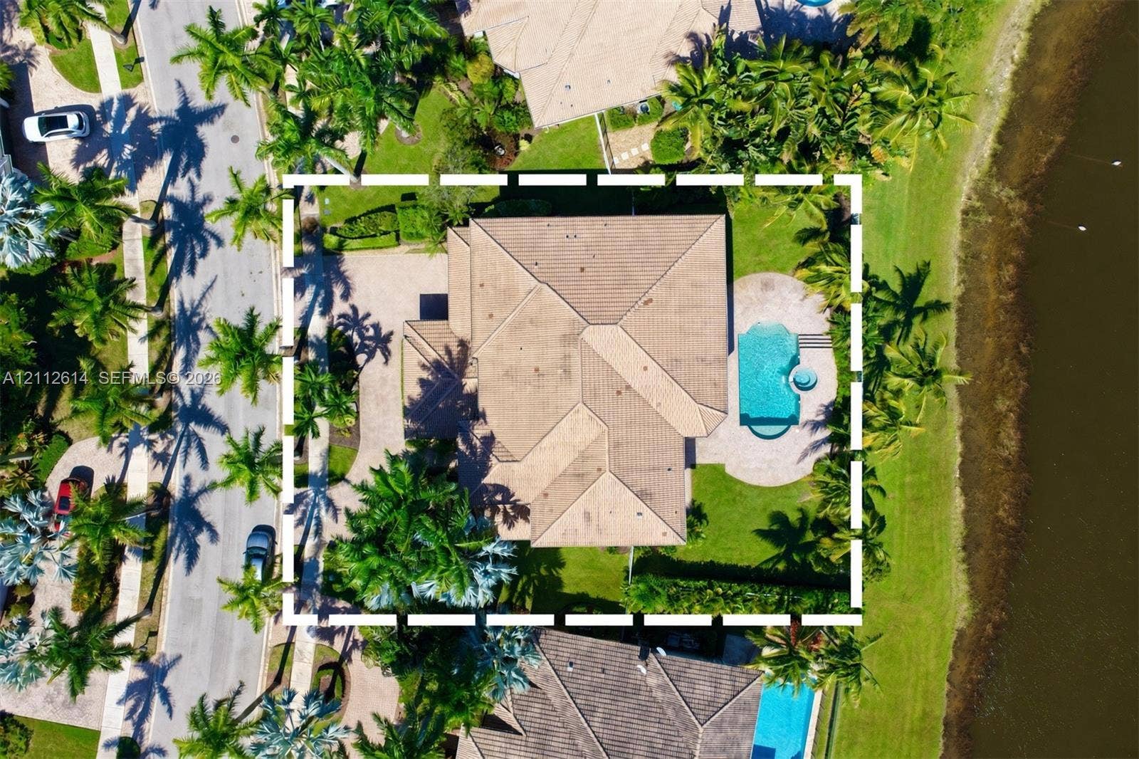 1422 Victoria Isle Drive, Weston, FL 33327 Aerial perspective of a property featuring a tile roof, an integrated swimming pool with a spa, paver hardscaping, and waterfront positioning