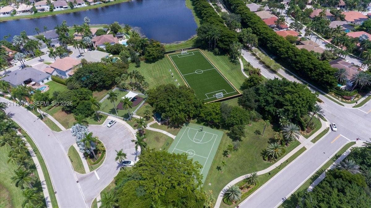 1422 Victoria Isle Drive, Weston, FL 33327 Recreational area featuring a soccer field, basketball court, paved parking, and landscaped grounds
