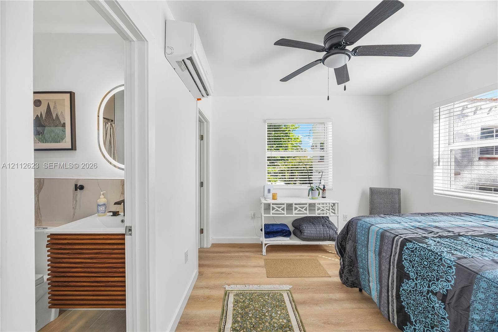 817 Tyler Street, #10, Hollywood, Hollywood, FL 33019 Interior space featuring wood-finish flooring, a wall-mounted ductless climate control unit, and a ceiling fan