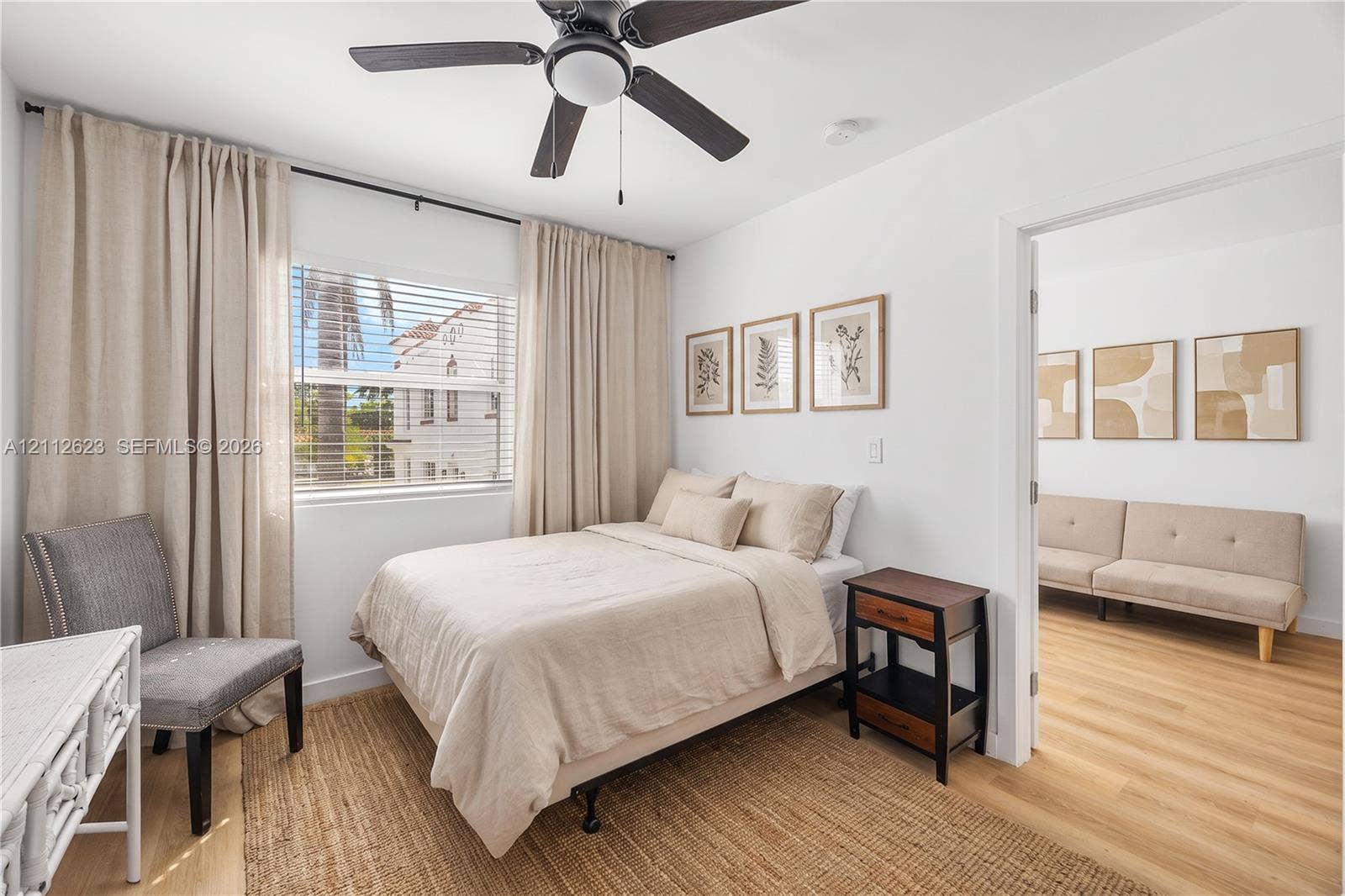 817 Tyler Street, #10, Hollywood, Hollywood, FL 33019 Neutral-toned interior featuring wood-finish flooring, a ceiling fan with integrated lighting, and a window with horizontal blinds