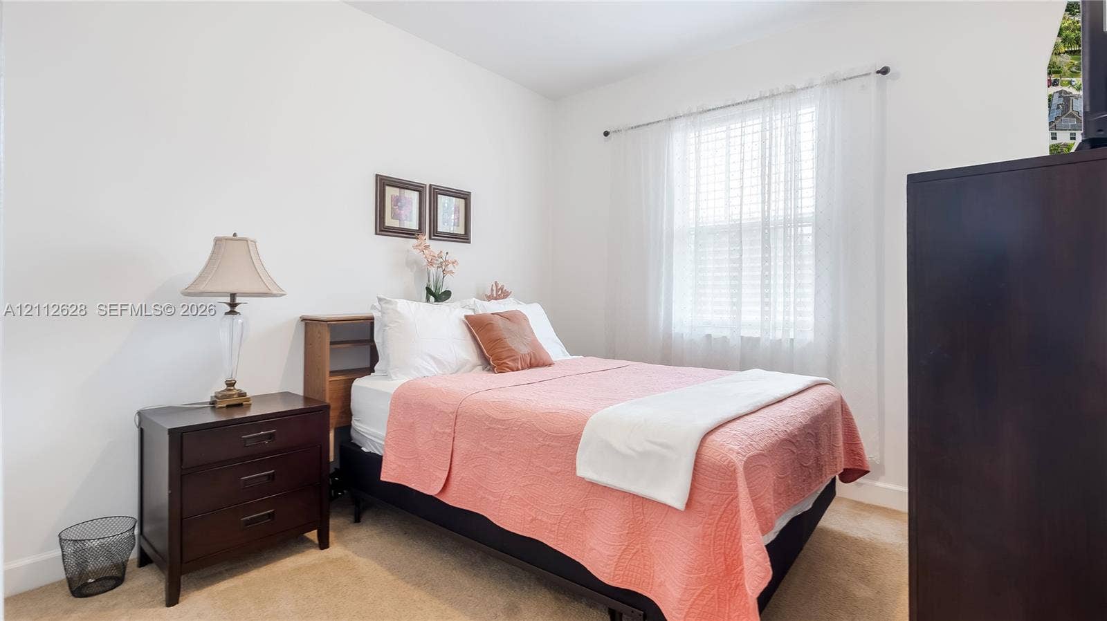 4445 NW 48th Terrace, Tamarac, Tamarac, FL 33319 A serene secondary bedroom bathed in natural light, offering a comfortable retreat ideal for family, guests, or a stylish home office setup.