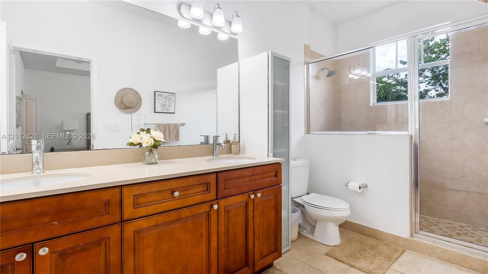 4445 NW 48th Terrace, Tamarac, Tamarac, FL 33319 The oversized ensuite bathroom features a bright, spa-inspired walk-in shower with elegant tilework and natural light, creating a refreshing retreat to start and end your day in pure comfort.