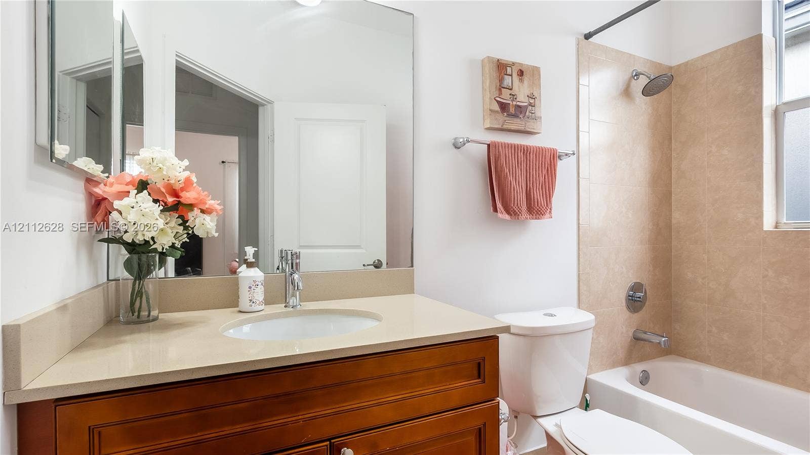 4445 NW 48th Terrace, Tamarac, Tamarac, FL 33319 A beautifully maintained secondary bathroom featuring a spacious vanity, warm finishes, and a bright shower-tub combinationperfect for guests, family, or multigenerational living.