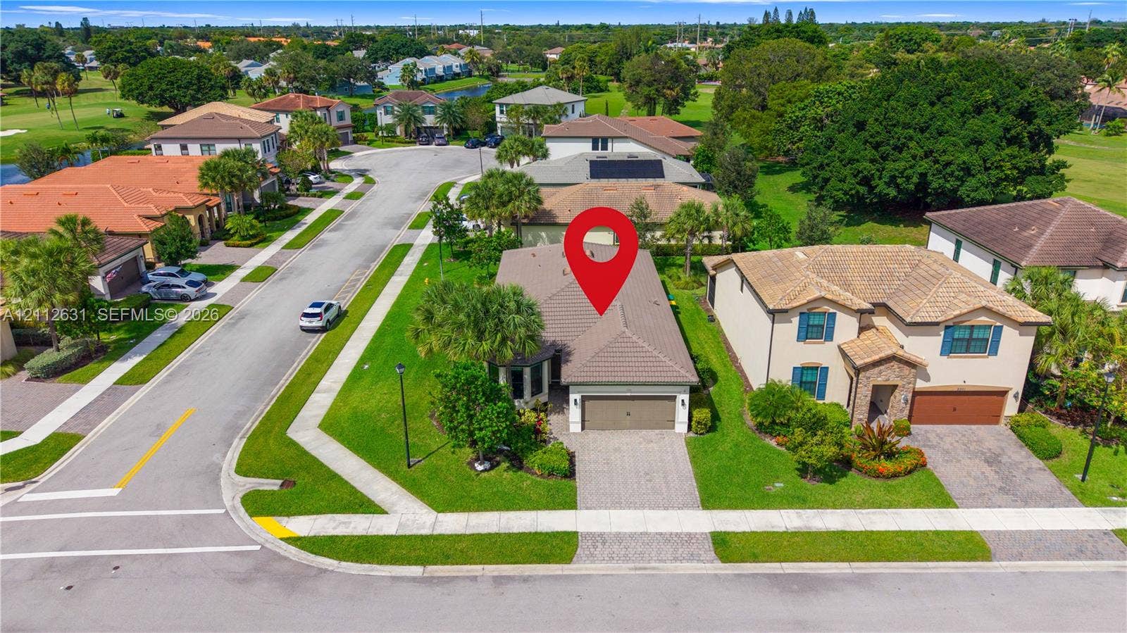 8257 NW 79th Avenue, Tamarac, FL 33321 Single-story residence featuring a concrete tile roof, paver driveway, and an attached two-car garage, situated on a lot with manicured turf