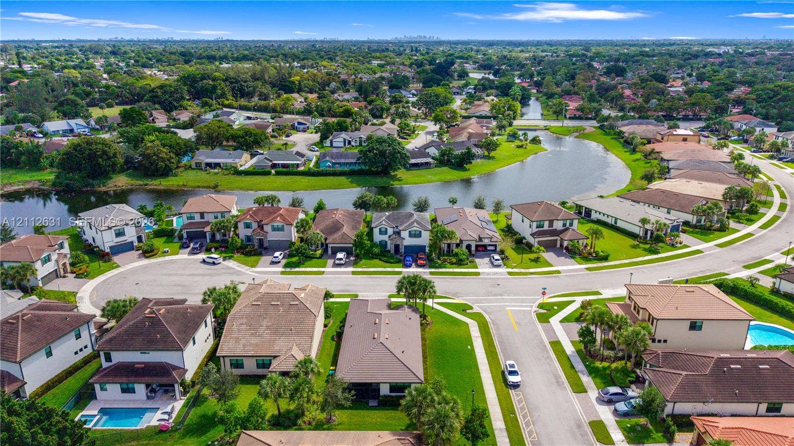8257 NW 79th Avenue, Tamarac, FL 33321 Aerial perspective of a residential community featuring winding paved streets, manicured landscaping, and a central water feature