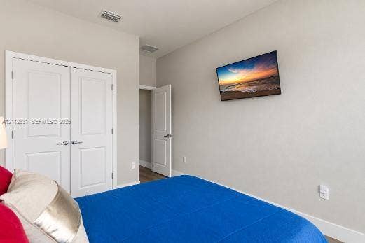 8257 NW 79th Avenue, Tamarac, FL 33321 Neutral interior featuring light-toned walls, double-panel closet doors, and wood-finish flooring