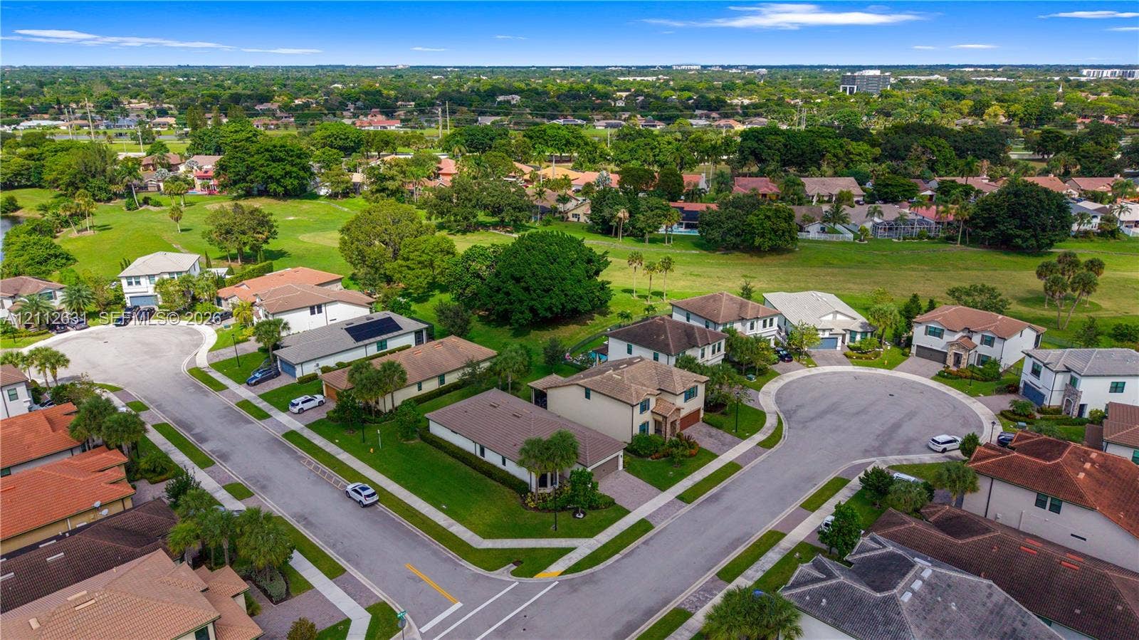8257 NW 79th Avenue, Tamarac, FL 33321 Aerial perspective of a residential neighborhood featuring cul-de-sac streets, surrounding greenery, and proximity to an expansive open-space fairway