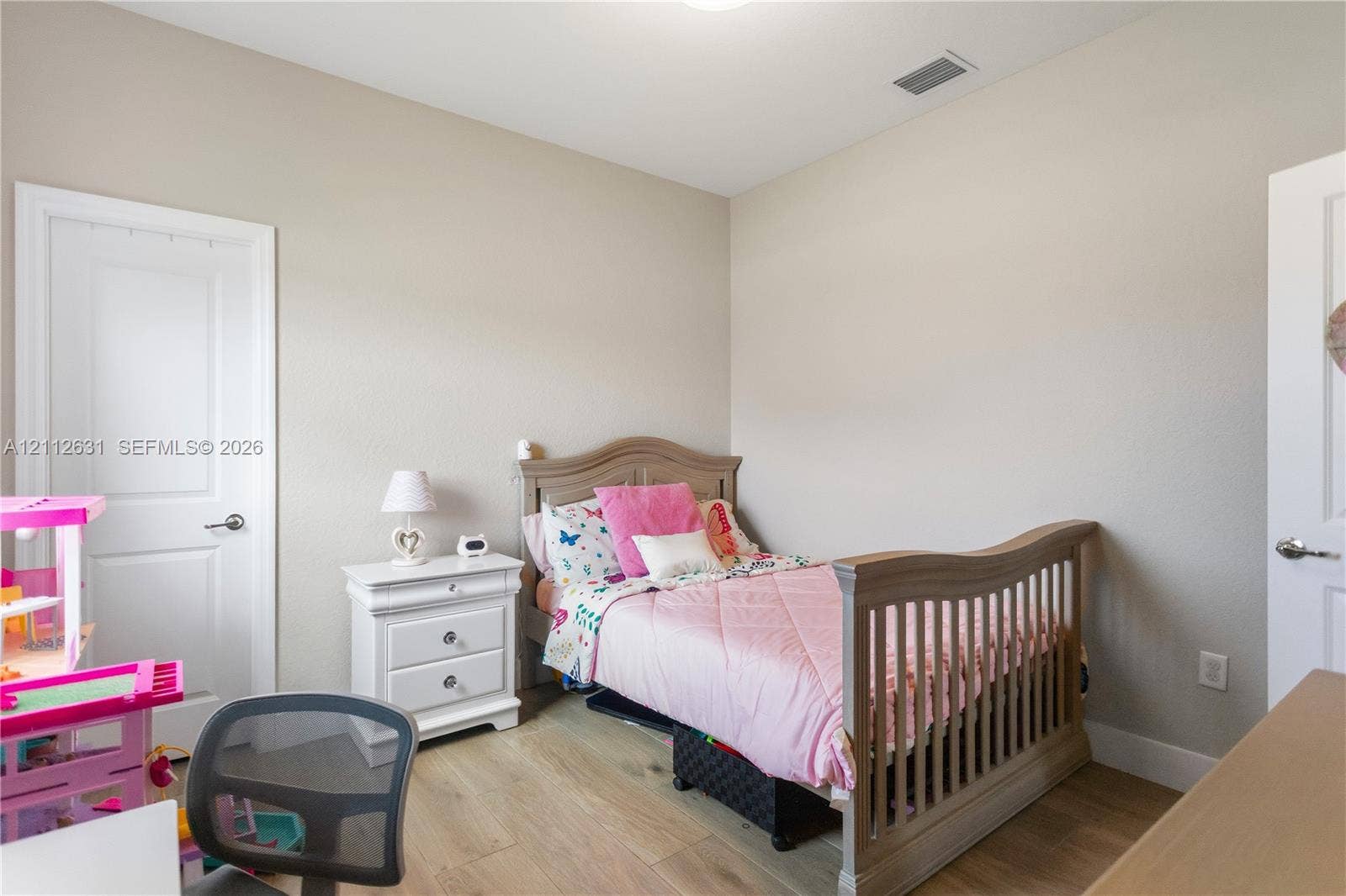 8257 NW 79th Avenue, Tamarac, FL 33321 Room with wood-finish flooring, neutral wall paint, and two interior doors with brushed nickel hardware
