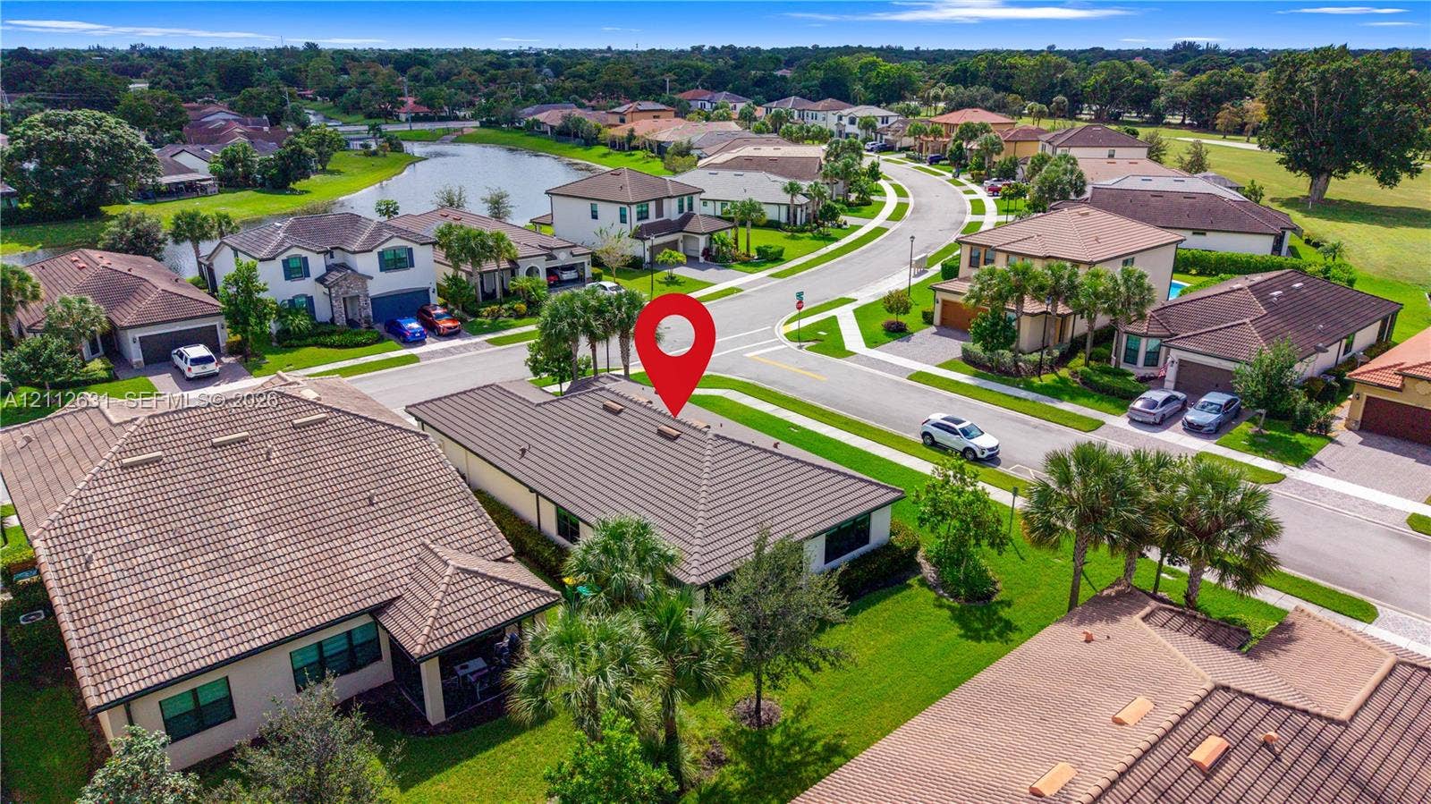 8257 NW 79th Avenue, Tamarac, FL 33321 Aerial perspective of a residential property featuring a hip roof, stucco exterior, integrated garage, and manicured landscaping