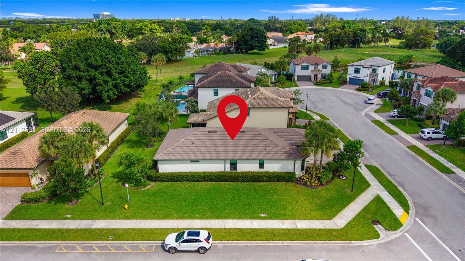 8257 NW 79th Avenue, Tamarac, FL 33321 Single-story residence featuring a tile roof, light-toned exterior finish, corner lot placement, mature landscaping, and an attached multi-car garage