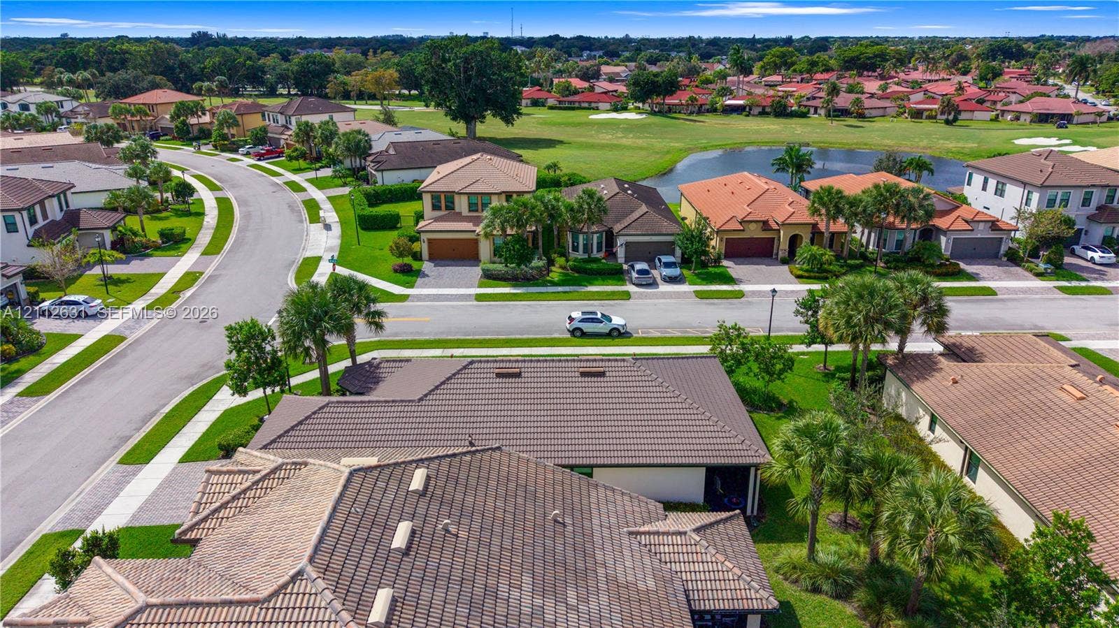 8257 NW 79th Avenue, Tamarac, FL 33321 Aerial perspective of residential neighborhood featuring tile roofing, paved streets, manicured landscaping, and pond