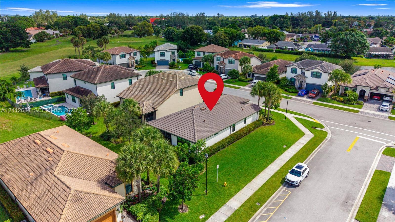 8257 NW 79th Avenue, Tamarac, FL 33321 Aerial perspective of a corner lot property featuring a tiled roof, manicured lawn, and mature palm landscaping