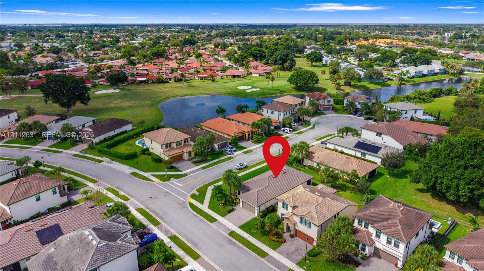 8257 NW 79th Avenue, Tamarac, FL 33321 Aerial perspective of a multi-story residence featuring a tile roof, paved driveway, multi-car garage, and landscaped front yard