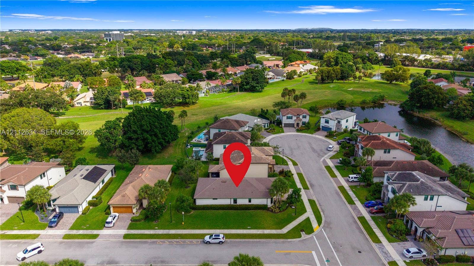 8257 NW 79th Avenue, Tamarac, FL 33321 Aerial perspective of a corner-lot property featuring a multi-pitched shingled roof, manicured lawn, and paved driveway