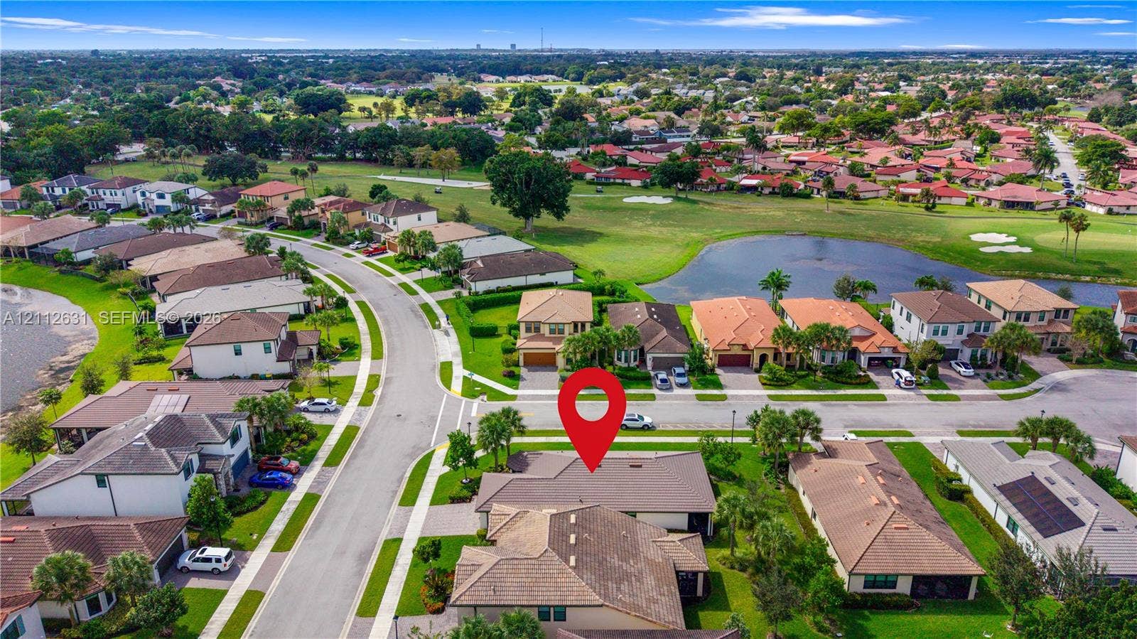 8257 NW 79th Avenue, Tamarac, FL 33321 Aerial perspective featuring a multi-hipped shingle roof, paver driveway, and landscaped front lawn situated within a residential community