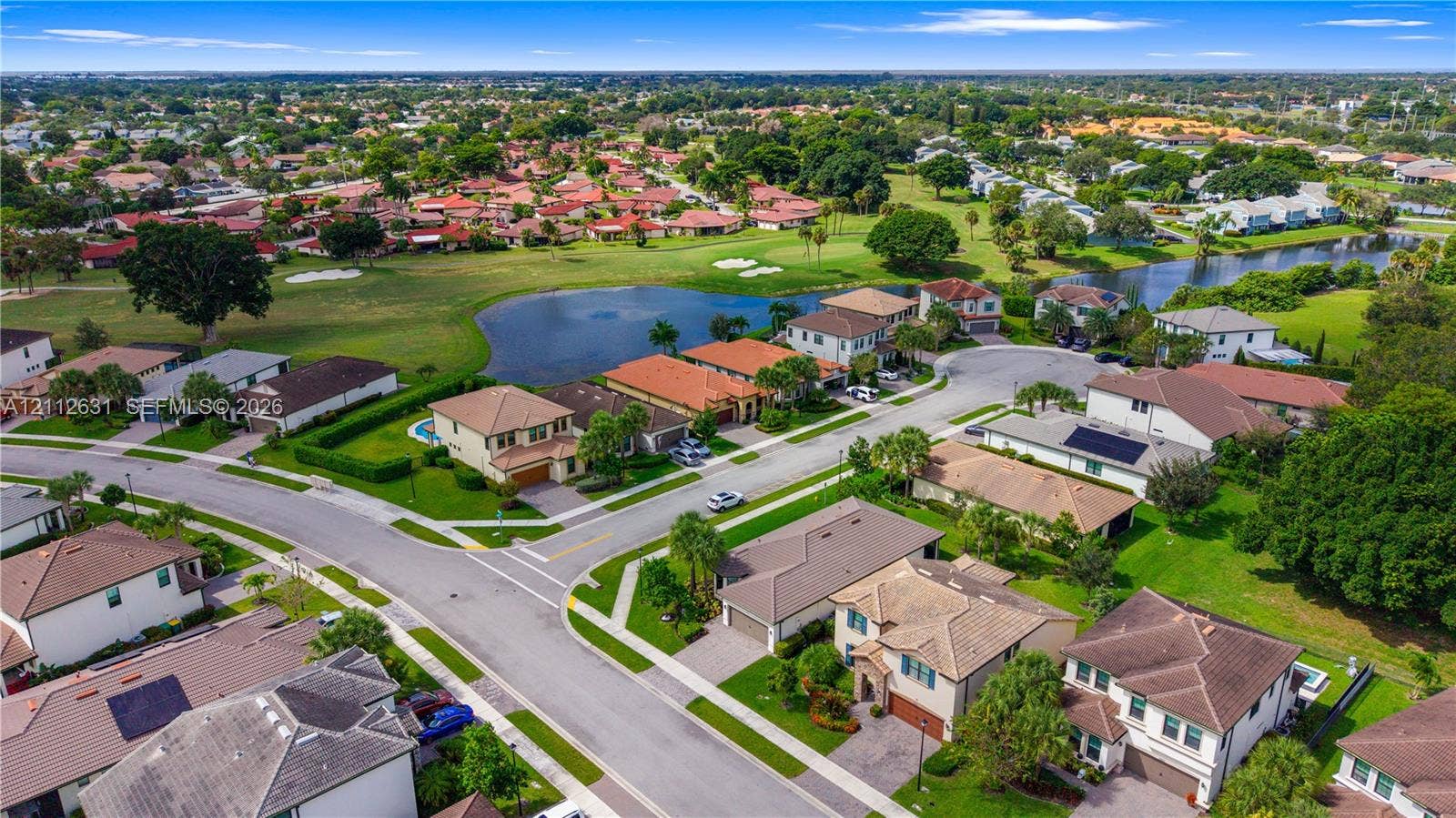 8257 NW 79th Avenue, Tamarac, FL 33321 Aerial perspective of a suburban neighborhood featuring residential lots with cul-de-sac streets, integrated water features, and manicured landscaping
