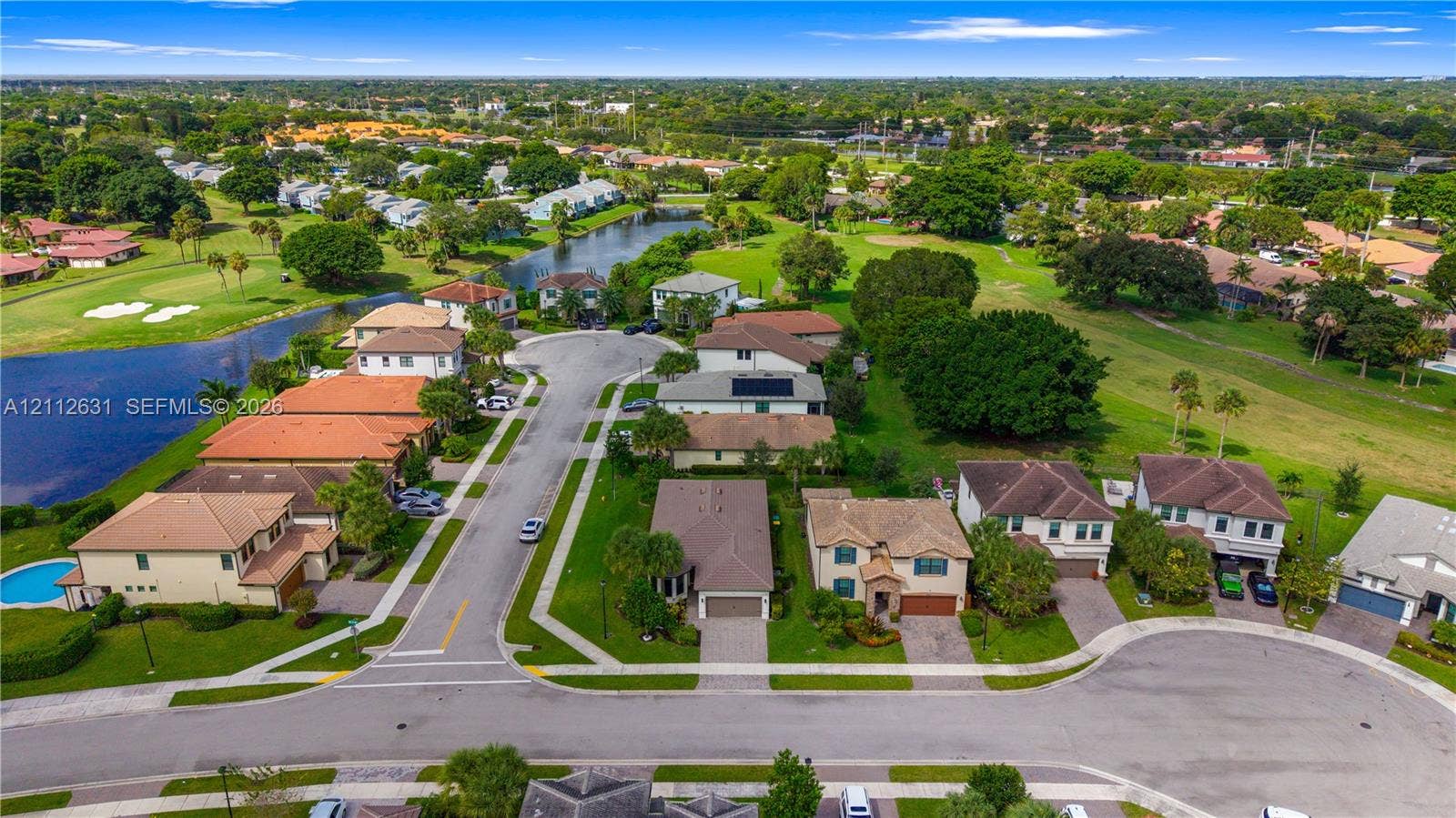 8257 NW 79th Avenue, Tamarac, FL 33321 Aerial perspective of a residential community featuring paved cul-de-sac streets, established landscaping, integrated water features, and expansive greenery