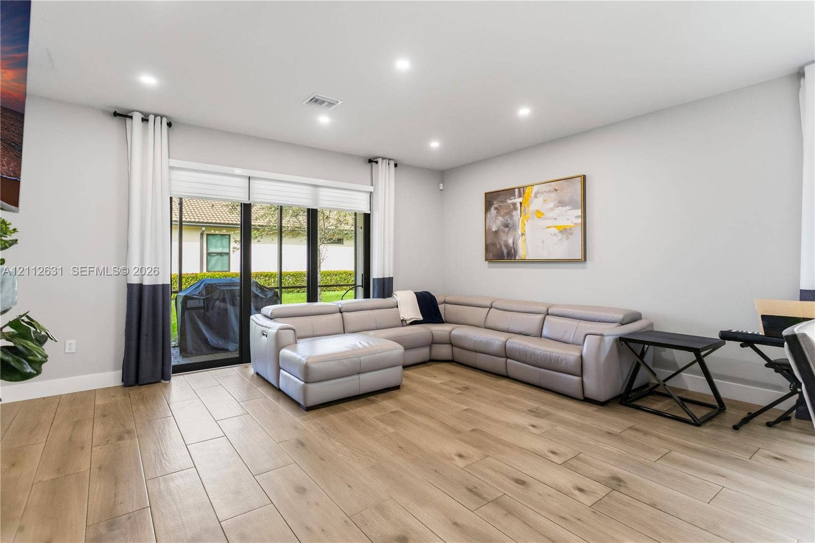 8257 NW 79th Avenue, Tamarac, FL 33321 Living area featuring wood-finish flooring, recessed lighting, and large sliding glass doors with black framing