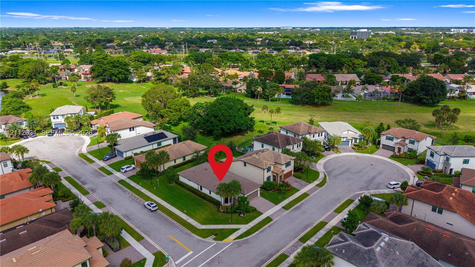 8257 NW 79th Avenue, Tamarac, FL 33321 Aerial perspective of a single-story residence situated on a corner lot featuring a multi-hip roof, integrated garage, and expansive lawn area