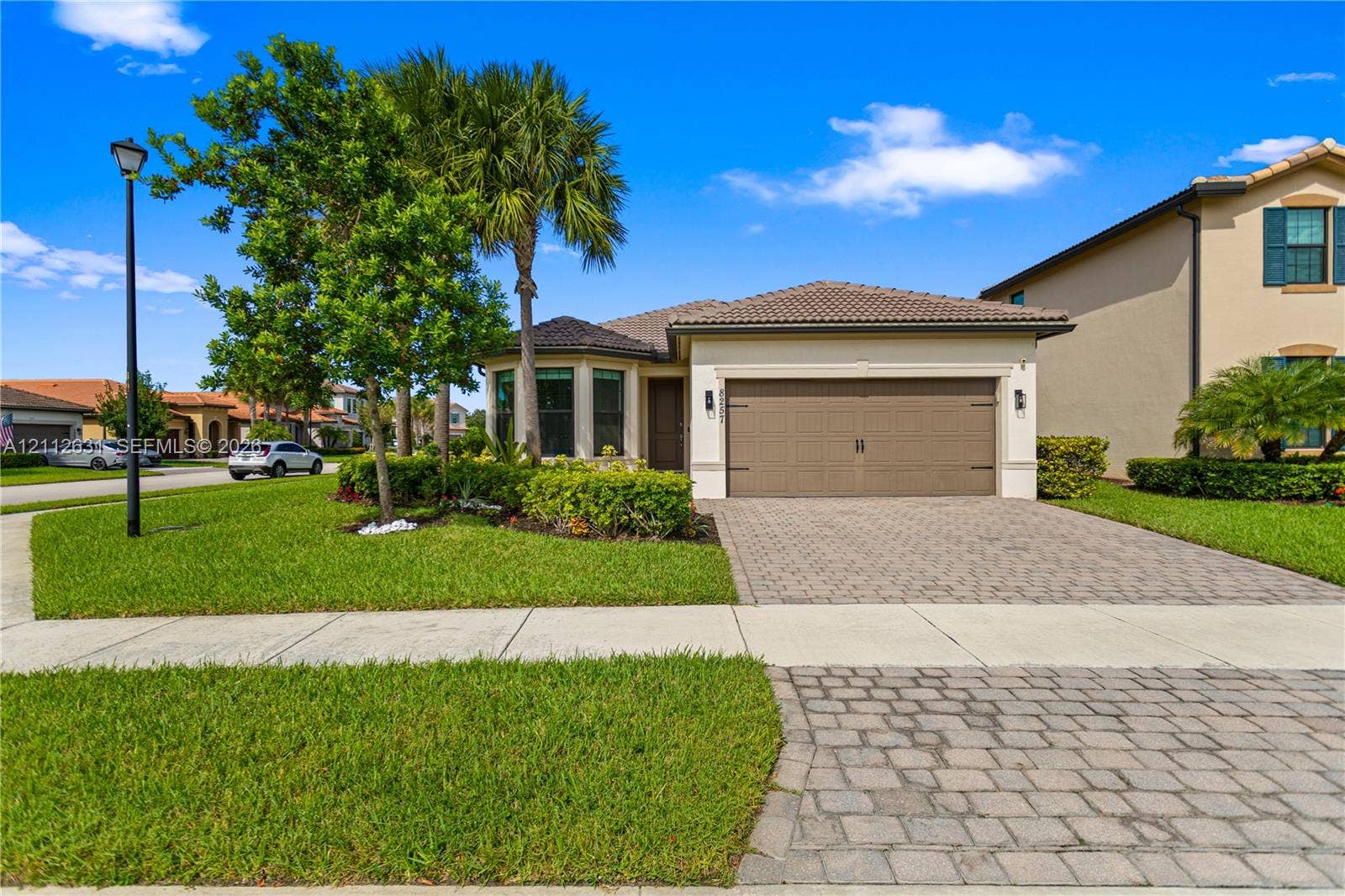 8257 NW 79th Avenue, Tamarac, FL 33321 Stucco exterior with a tiled roof, paver driveway, and an attached two-car garage