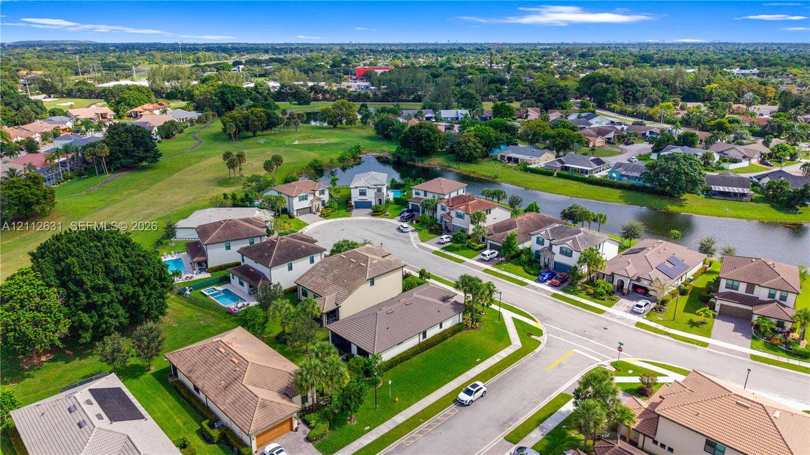 8257 NW 79th Avenue, Tamarac, FL 33321 Aerial perspective of a residential neighborhood featuring homes with tile roofing, mature landscaping, manicured lawns, and waterfront access
